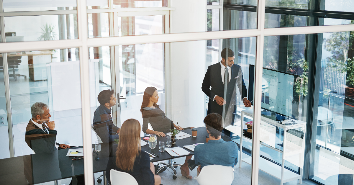 Second-generation Indian business leaders discussing growth strategy with senior family members in a boardroom