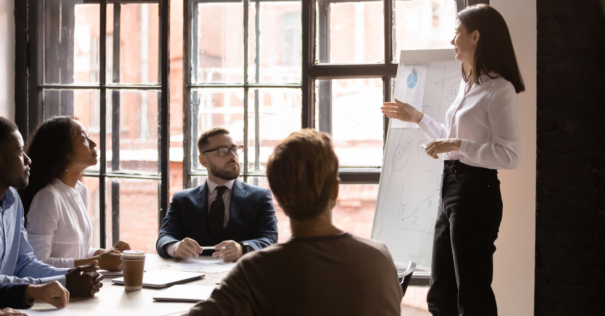 Indian B2B sales and marketing teams reviewing strategy documents together in a modern boardroom